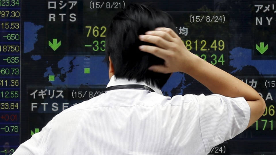 A man looks at a stock quotation board outside a brokerage in Tokyo.