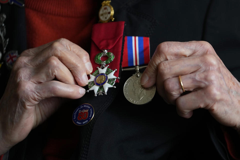 Marie Scott who was a serving Wren and switchboard operator at the time of D-Day, holds up her medals, at her home in London, Thursday, April 25, 2024. D-Day, took place on June 6, 1944, the invasion of the beaches at Normandy in France by Alied forces during World War II. (AP Photo/Kirsty Wigglesworth)