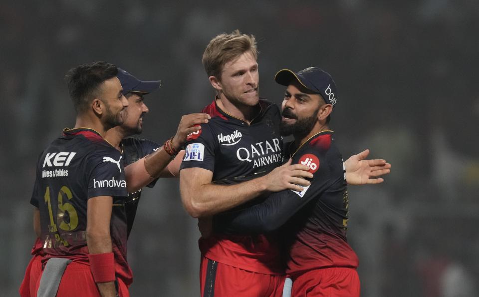 Royal Challengers Bangalore's Virat Kohli, right, congratulates David Willey for taking the wicket of Kolkata Knight Riders' Mandeep Singh during the Indian Premier League (IPL) cricket match between Royal Challengers Bangalore and Kolkata Knight Riders in Kolkata, India, Thursday, April 6, 2023. (AP Photo/Bikas Das)