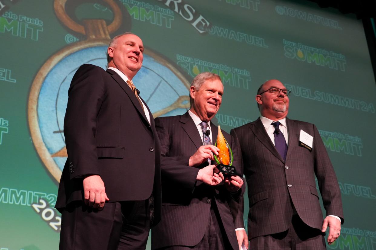 Executive director of the Iowa Renewable Fuels Association (IRFA) Monte Shaw, left, and president of the IRFA Brad Wilson, right, present USDA secretary Tom Vilsack with the "Lifetime Champion of Renewable Fuels" award at the Iowa Renewable Fuels Summit on Thursday, Jan. 11, 2024, at The Meadows Event Center, in Des Moines.