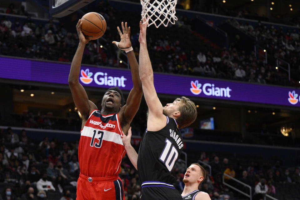 Washington Wizards center Thomas Bryant (13) goes to the basket against Sacramento Kings forward Domantas Sabonis (10) during the first half of an NBA basketball game Saturday, Feb. 12, 2022, in Washington. (AP Photo/Nick Wass)