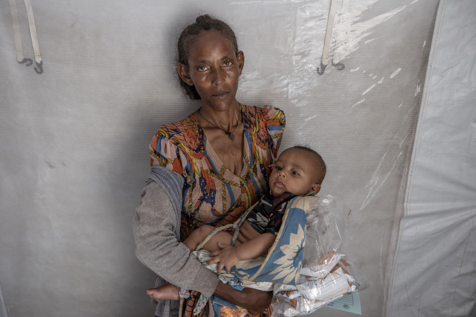 Tigrinyan refugee 38-year-old Rega Tsfay, malnourished mother of her 3-moth-old son Itbarak, stands for a photograph inside a tent, in Umm Rakouba refugee camp in Qadarif, eastern Sudan, Thursday, Dec. 10, 2020. (AP Photo/Nariman El-Mofty)