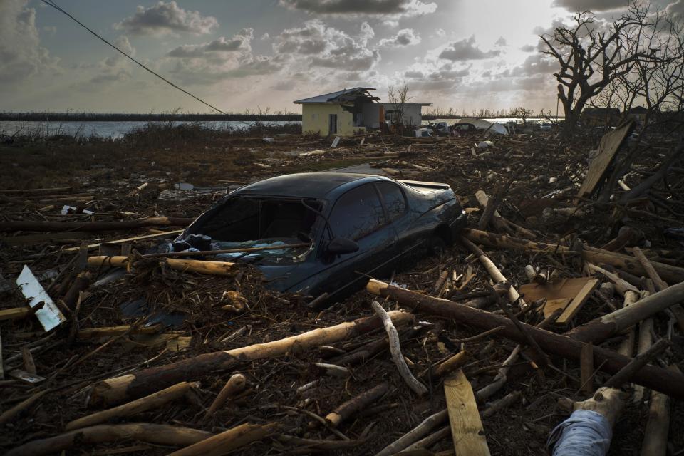 A car is sunk in the wreckage and debris caused by Hurricane Dorian, in Mclean's Town, Grand Bahama, Bahamas, Wednesday Sept. 11, 2019. Bahamians are tackling a massive clean-up a week after Hurricane Dorian devastated the archipelago’s northern islands. Residents sift through debris as they try to save prized possessions and prepare to rebuild from one of the strongest Atlantic hurricanes in history. (AP Photo/Ramon Espinosa)