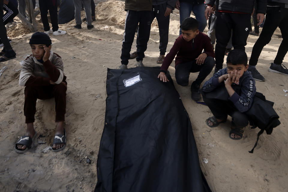 Palestinians mourn a relative killed in the Israeli bombardment of the Gaza Strip outside a morgue in Khan Younis on Monday, Jan. 22, 2024. (AP Photo/Mohammed Dahman)