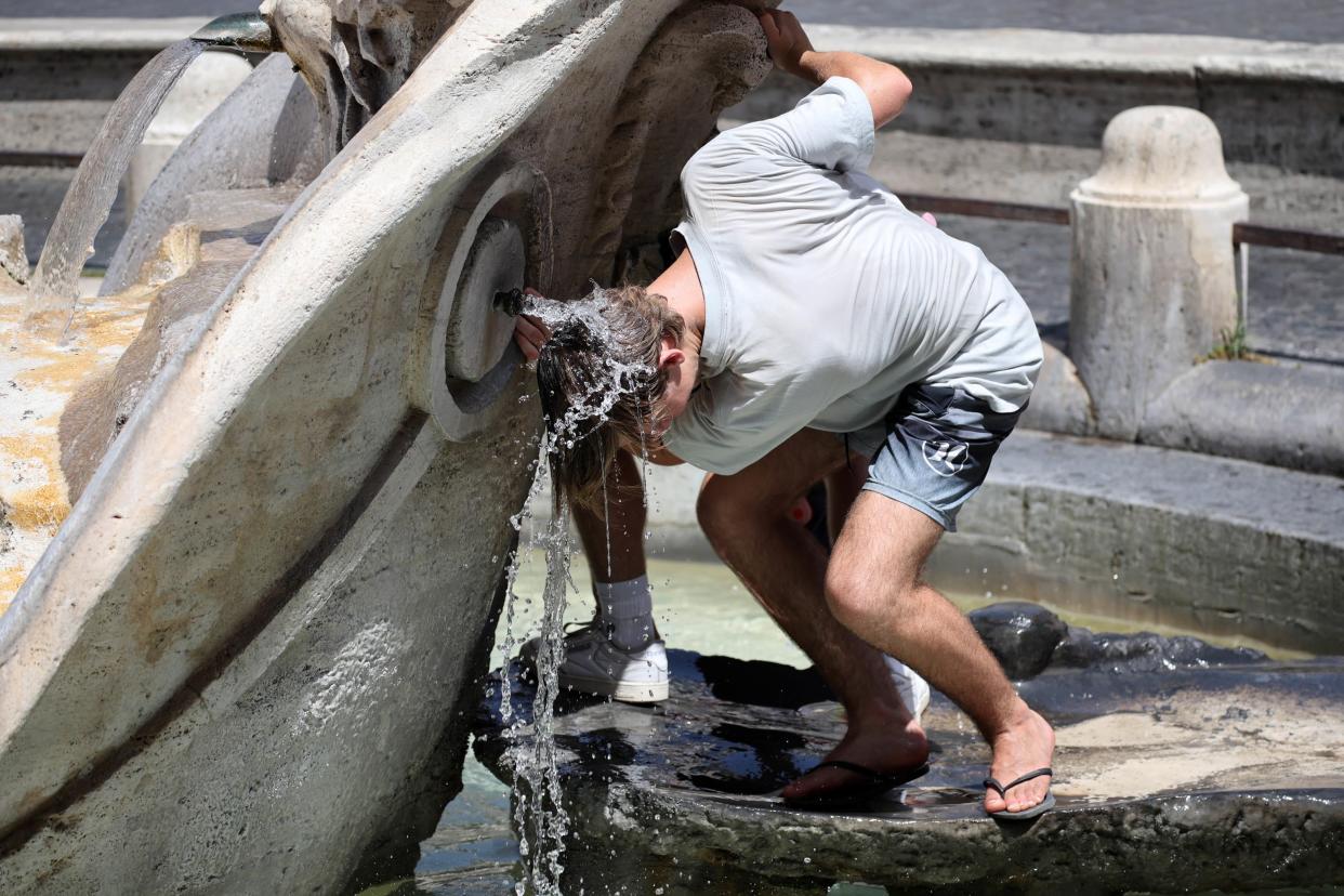 A man cools off in a fountain during a heat wave in Rome, Italy (EPA)