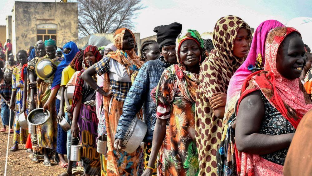 Women who fled war in Sudan queue for food rations