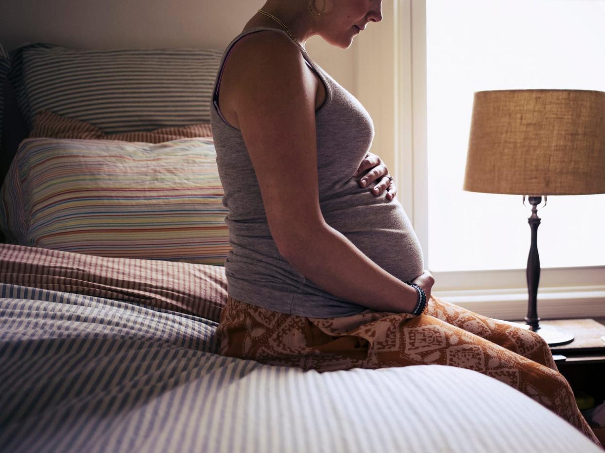 pregnant woman sitting on bed