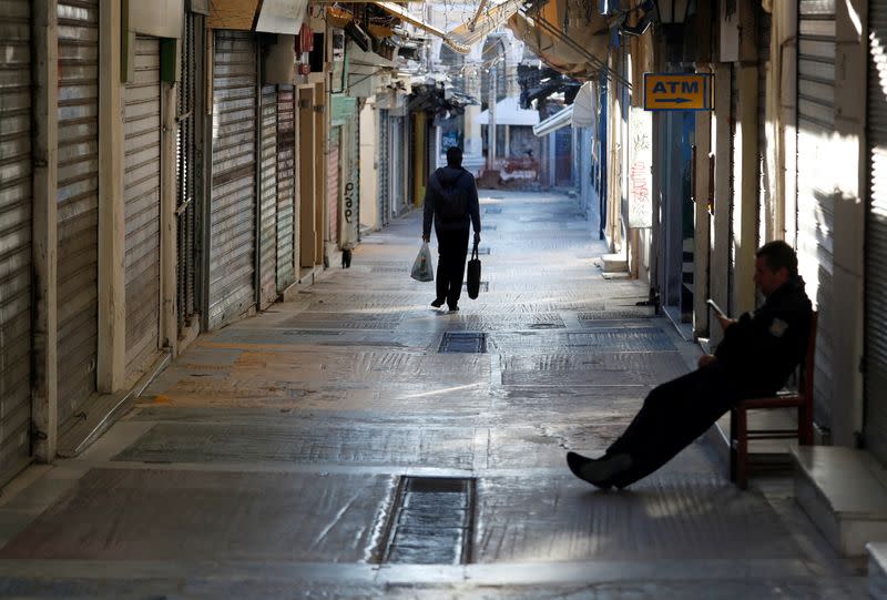 FILE PHOTO: A man walks on a street following the coronavirus disease (COVID-19) outbreak in Athens