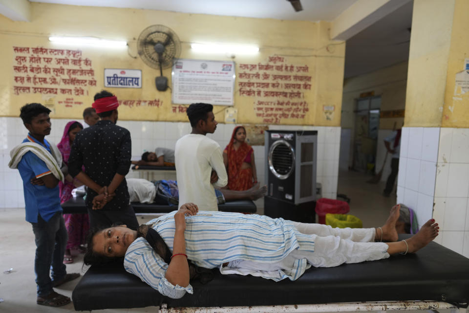 A woman suffering from heat related ailment lies on a stretcher at the foyer of government district hospital in Ballia, Uttar Pradesh state, India, Monday, June 19, 2023. Several people have died in two of India's most populous states in recent days amid a searing heat wave, as hospitals find themselves overwhelmed with patients. More than hundred people in the Uttar Pradesh state, and dozens in neighboring Bihar state have died due to heat-related illness. (AP Photo/Rajesh Kumar Singh)