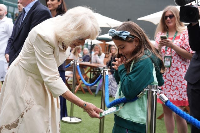 Camila inspects the Wimbledon pass belonging to Camila, daughter of Mexican tennis player Santiago Gonzalez