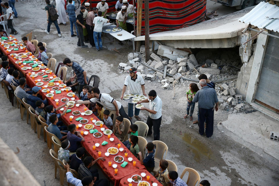 People gather for Iftar (breaking fast), organised by Adaleh Foundation, amidst damaged buildings during the holy month of Ramadan in the rebel held besieged Douma neighbourhood of Damascus, Syria, June 18, 2017. Picture taken June 18, 2017. REUTERS/Bassam Khabieh TPX IMAGES OF THE DAY