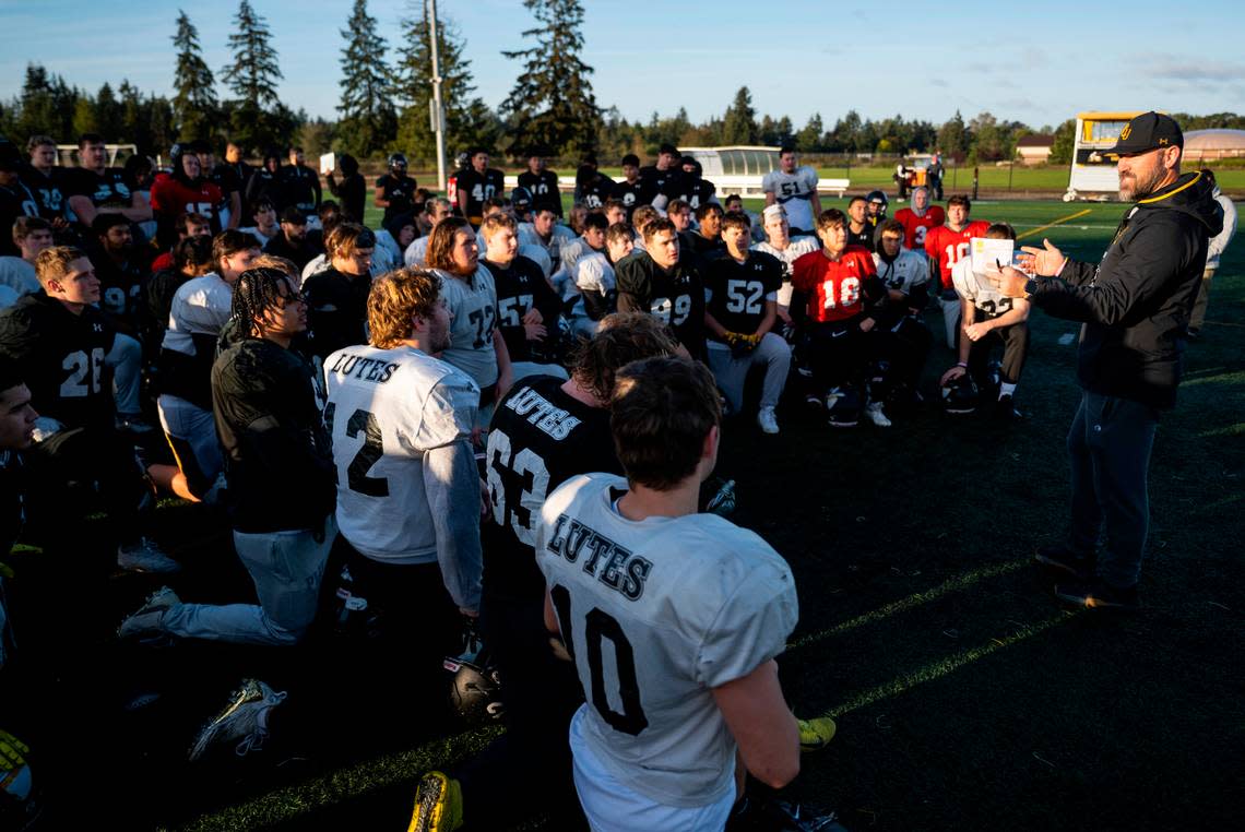 Pacific Lutheran University football head coach Brant McAdams talks with the team after practicing in the morning on the field at the school in Parkland, Wash. on Oct. 26, 2022.