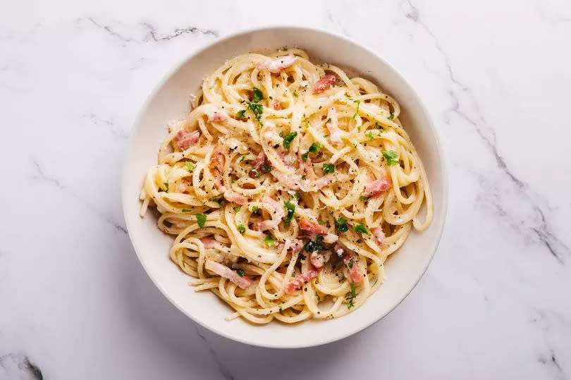 Flat lay of spaghetti carbonara on marble surface