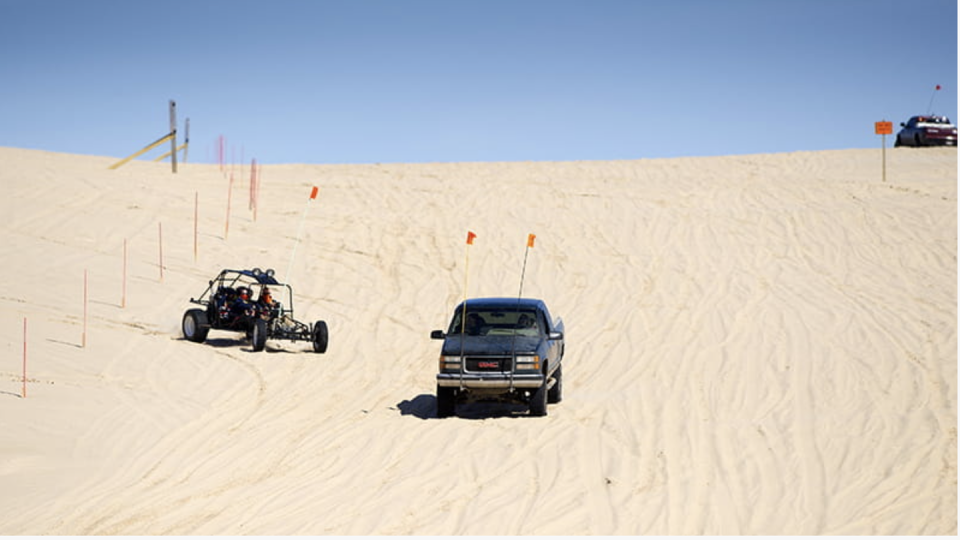 trucks driving on silver lake sand dunes in michigan