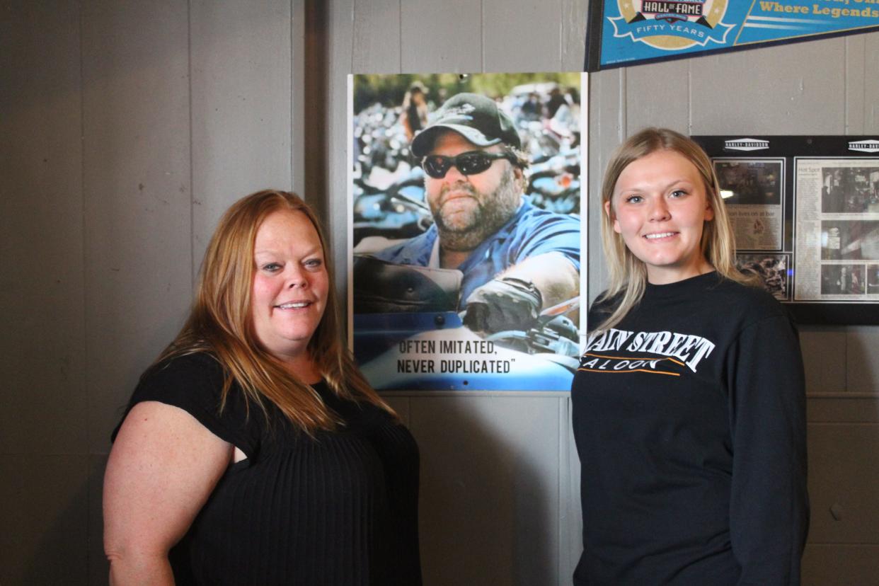 Owner Marlene Denholm, left, and assistant manager Brooke Kennamore, right, are the mother-daughter duo running Main Street Saloon. Between them is a photo of their father/grandfather and the restaurant's first owner, David Kennamore.