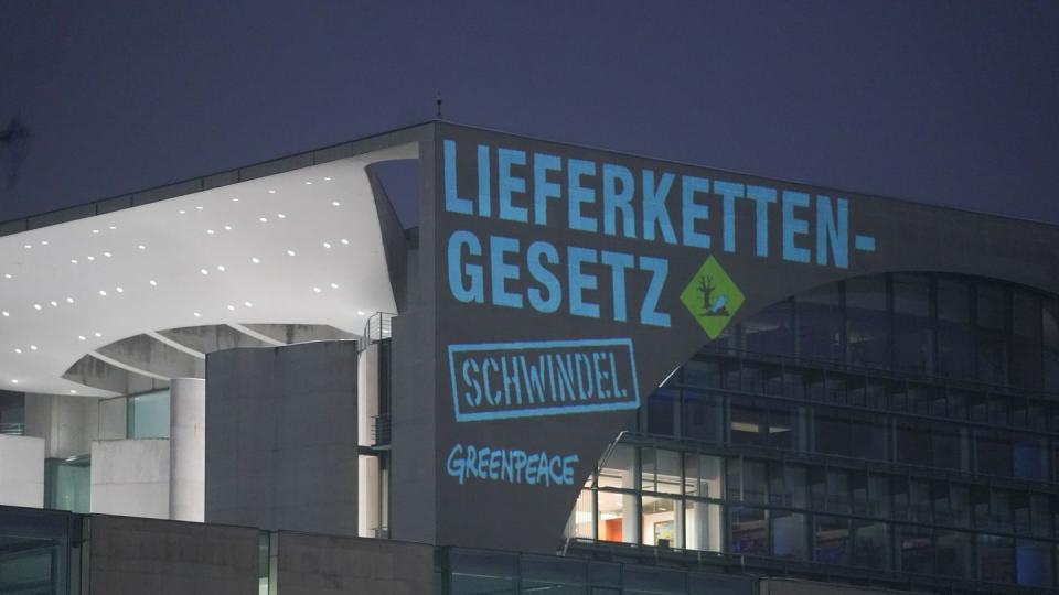 Bei einer Greenpeace-Aktion zum Lieferkettengesetz wird der Spruch «Lieferkettengesetz. Schwindel» an die Außenfassade des Bundeskanzleramts projiziert.