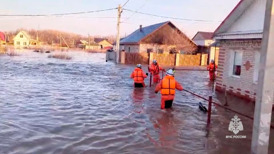 Rescuers make their way in a flooded residential area in the city of Orsk. - Russian Emergencies Ministry via Reuters