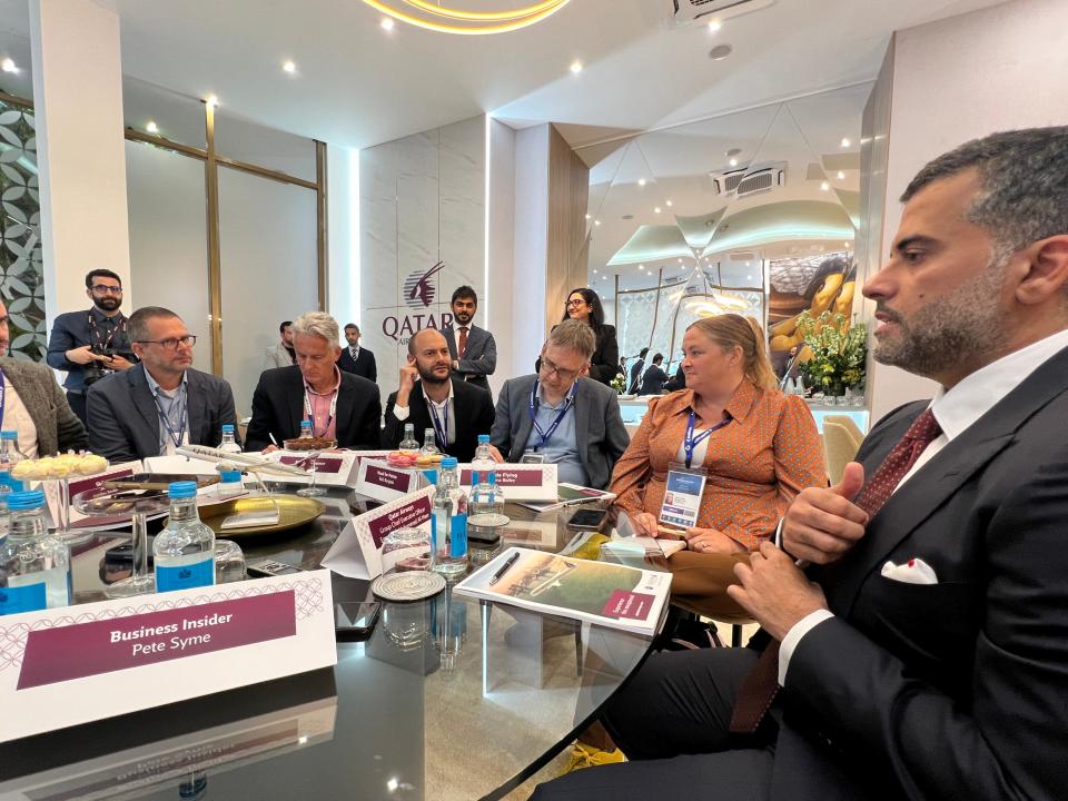 Reporters sat around a table listen to Qatar Airways CEO Badr Mohammed Al Meer on the sidelines of the Farnborough International Airshow, July 2024.