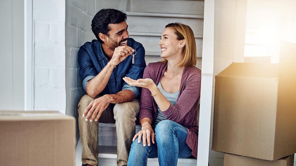 Shot of a man handing his wife the keys of their new home.