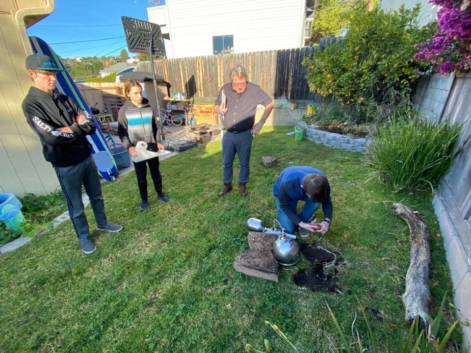 From left to right, Tim Nelligan’s two sons, Mason Nelligan and Jacob Nelligan, and Steve Hoyt watch Mark Mattison, one of Hoyt’s employees, insert a soil vapor probe and summa canister into the yard of Marcia Papich, which is adjacent to Susan Flores’ yard, in December 2020. They were testing for evidence of human decomposition in the search for Kristin Smart’s body.