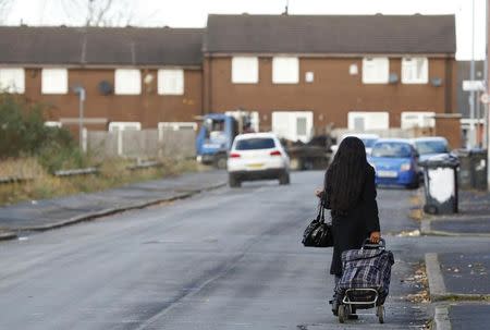 A woman pulls her shopping trolley in the Gorton district of Manchester, Britain November 23, 2016. REUTERS/Phil Noble