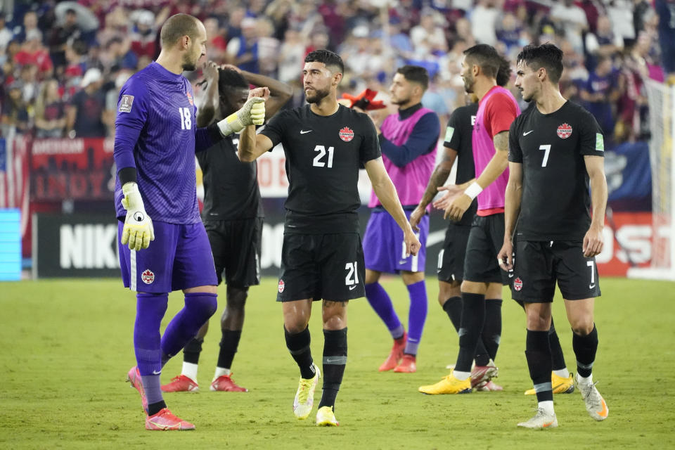 Canada goalkeeper Milan Borjan (18) bumps fists with midfielder Jonathan Osorio (21) as they leave the pitch following a 1-1 draw with the United States in a World Cup soccer qualifier Sunday, Sept. 5, 2021, in Nashville, Tenn. (AP Photo/Mark Humphrey)