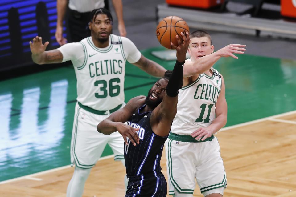 Orlando Magic's James Ennis III, center, struggles to control the ball against Boston Celtics' Payton Pritchard (11) and Marcus Smart (36) during the first half on an NBA basketball game, Sunday, March 21, 2021, in Boston. (AP Photo/Michael Dwyer)