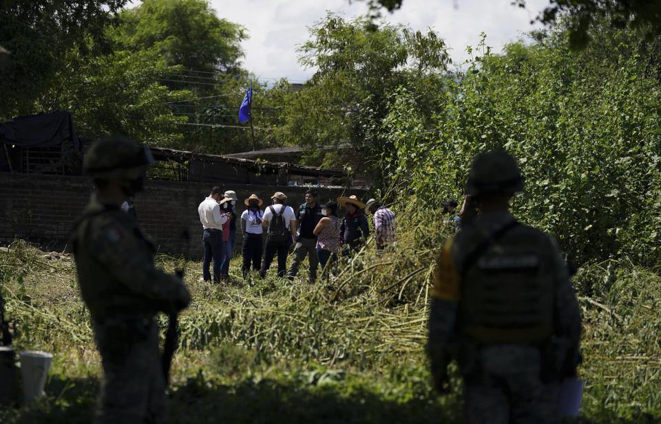 Relatives of missing people and members of the National Search Commission meet in an area where bodies are suspected to be buried, during the sixth National Search Brigade for disappeared people at a cemetery in Jojutla, Mexico, Monday, Oct. 11, 2021. The government's registry of Mexico’s missing has grown more than 20% in the past year and now approaches 100,000. (AP Photo/Fernando Llano)