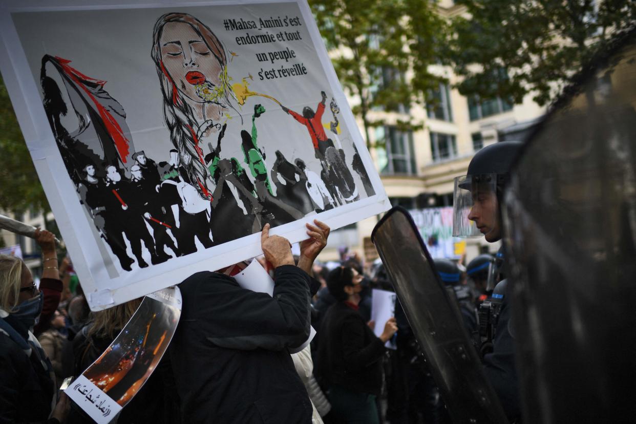 People face riot police as they take part in a demonstration in support of Iranian protesters in Paris on Sept. 25, 2022.