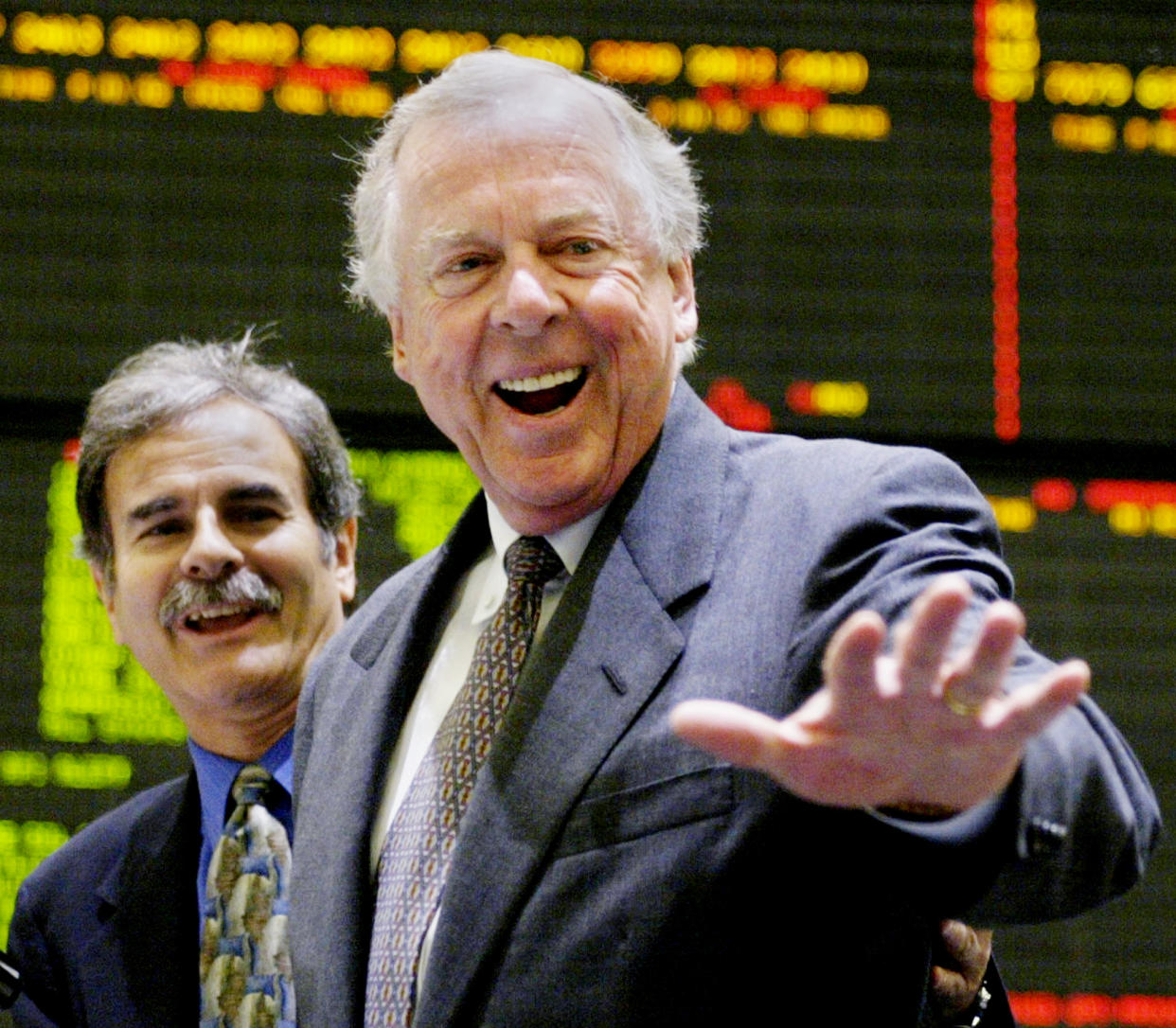 T. Boone Pickens, the founder of Texas based Mesa Petroleum, waves after ringing the opening bell at the New York Mercantile Exchange on May 2, 2003. Pickens was in New York attending a symposium before visiting the exchange. NYME Vice Chairman Michael Steinhause (L) stood with Pickens. REUTERS/Peter Morgan  