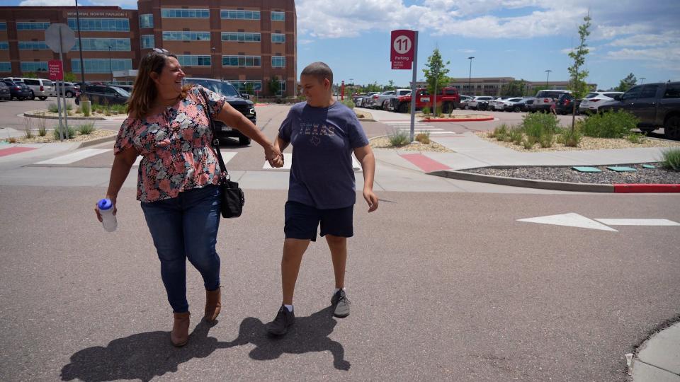 Screen capture from "Shift: The RAGBRAI Documentary": Torie Giffin holds her son Daniel's hand as they walk up to Children's Hospital Colorado for an appointment in July 2022 in Colorado Springs.