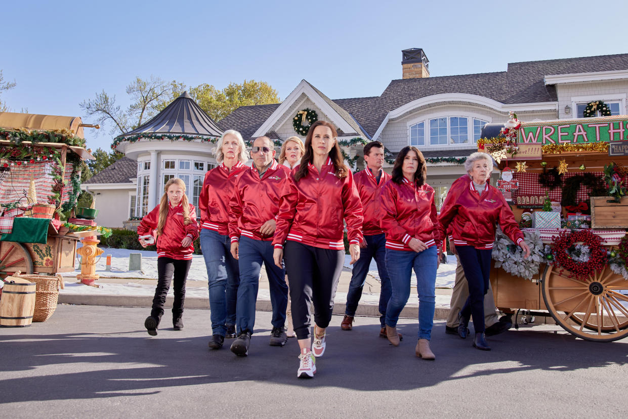 Charlotte Kay Witt, Carrie Morgan, Peter Jacobson, Melissa Peterman, Lacey Chabert, Wes Brown, Laura Wardle, Ellen Travolta in Haul Out the Holly: Lit Up. (2023 Hallmark Media/Natalie Cass)
