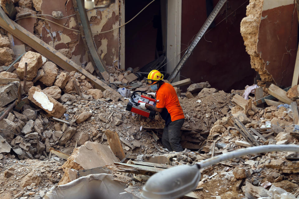 Un rescatista chileno sostiene un dispositivo para detectar señales mientras ayuda a su equipo que busca entre los escombros de un edificio derruido tras la explosión del mes pasado en el puerto de Beirut, Líbano, el viernes 4 de septiembre de 2020. (AP Foto/Bilal Hussein)