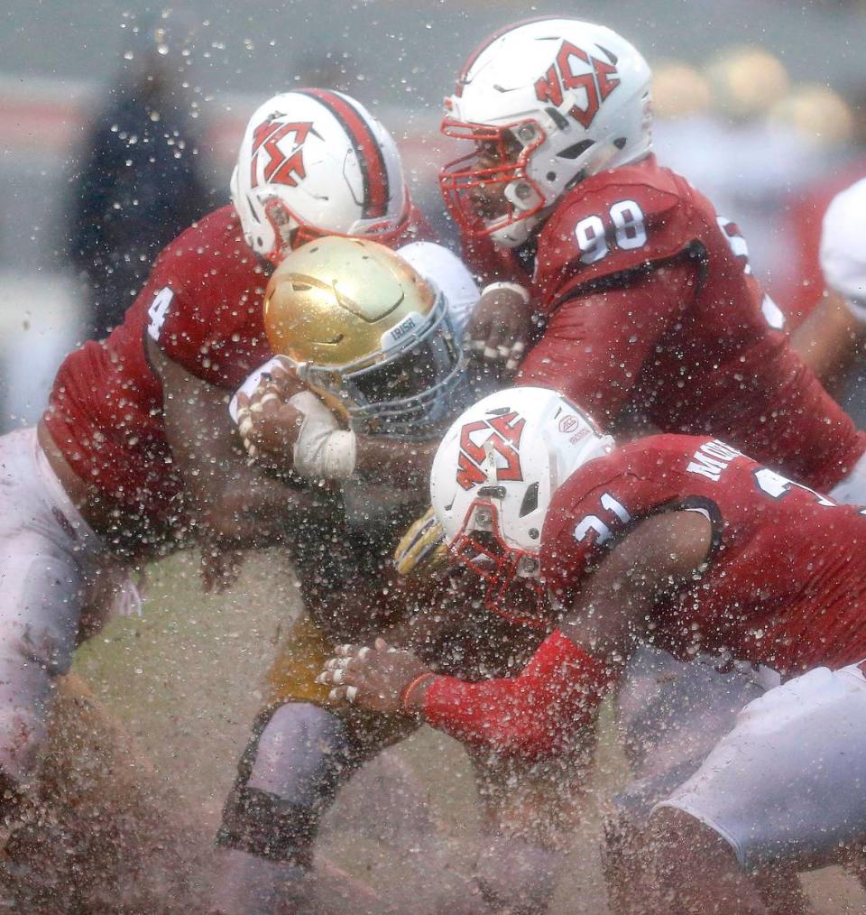 N.C. State’s Jerod Fernandez (4), B.J. Hill (98) and Jarius Morehead (31) tackle Notre Dame running back Josh Adams (33) during the first half of the Wolfpack’s game against Notre Dame at Carter-Finley Stadium in Raleigh, N.C., Saturday, Oct. 8, 2016.