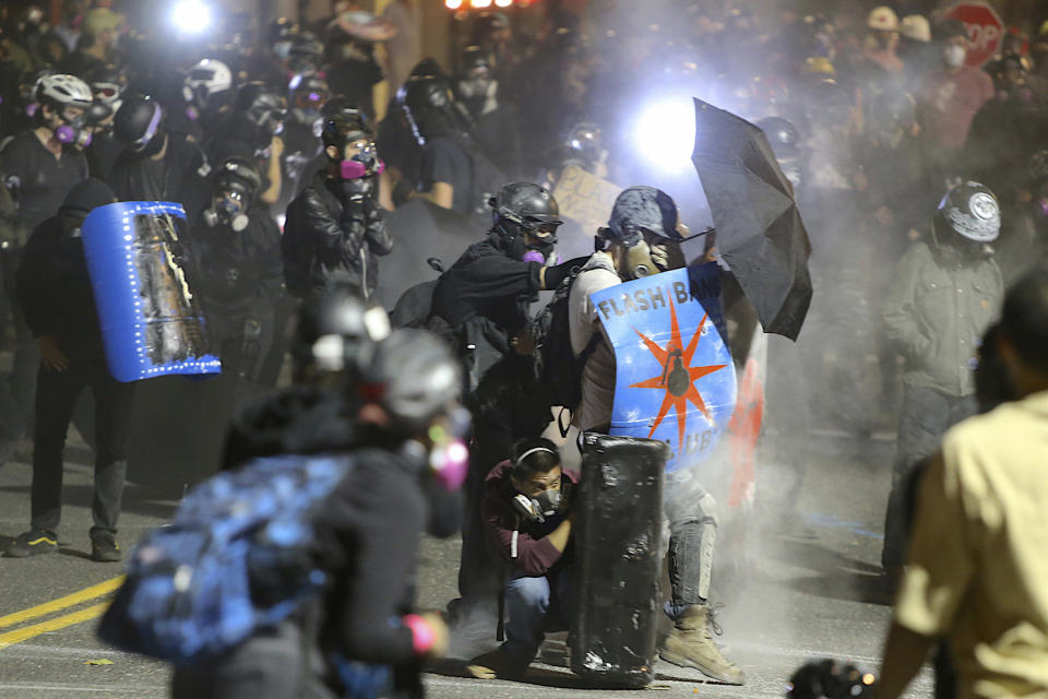 Protesters confront federal officers outside of the ICE building in Portland, Ore., Wednesday, Aug. 19, 2020. Protesters in Portland have clashed with federal agents for the first time since July in a demonstration that targeted a U.S. Immigration and Customs Enforcement building.(Sean Meagher/The Oregonian via AP)