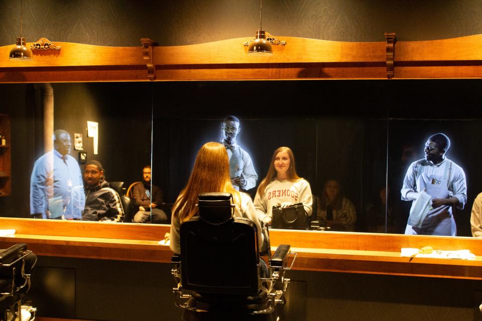 Members of the Seminole State College President’s Leadership Class toured Tulsa’s Greenwood District on March 24. Cepado Wilkins, Jr. (left), of Shawnee, and Sydney Winchester (right), of Prague, sit in a barbershop re-creation and listen to holographic actors describe life in Greenwood before violence broke out.