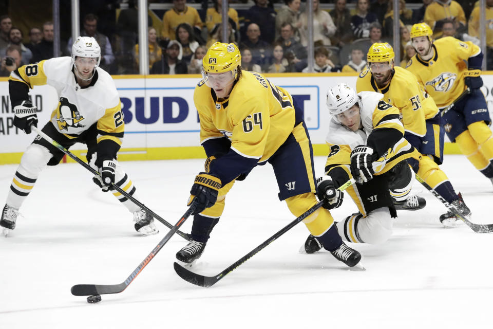 Nashville Predators center Mikael Granlund (64), of Finland, moves the puck ahead of Pittsburgh Penguins defenseman John Marino (6) during the second period of an NHL hockey game Friday, Dec. 27, 2019, in Nashville, Tenn. (AP Photo/Mark Humphrey)