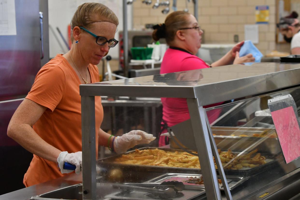 Deidra Roberts prepares lunch for Heaton Middle School students in the cafeteria on Wednesday, May 25.