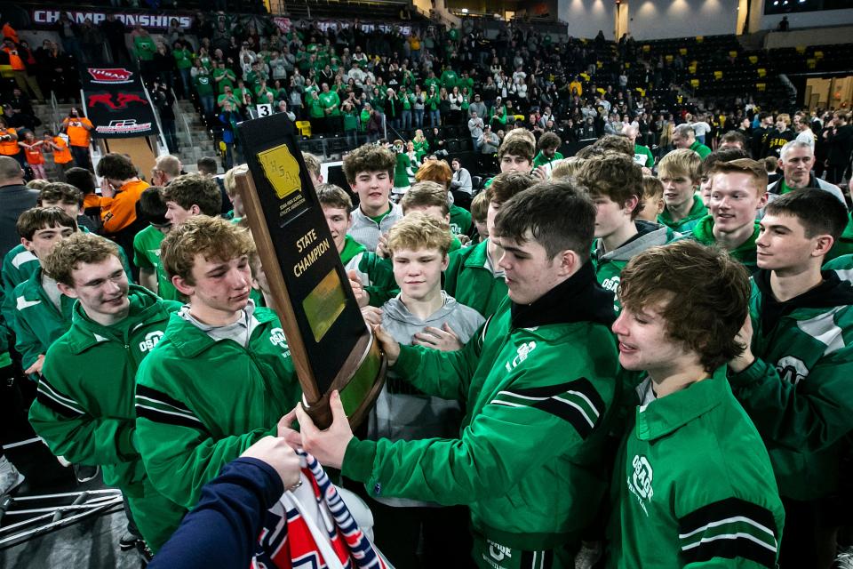 Osage wrestlers celebrate with their trophy during the Class 2A boys state wrestling duals, Saturday, Feb. 4, 2023, at Xtream Arena in Coralville, Iowa.