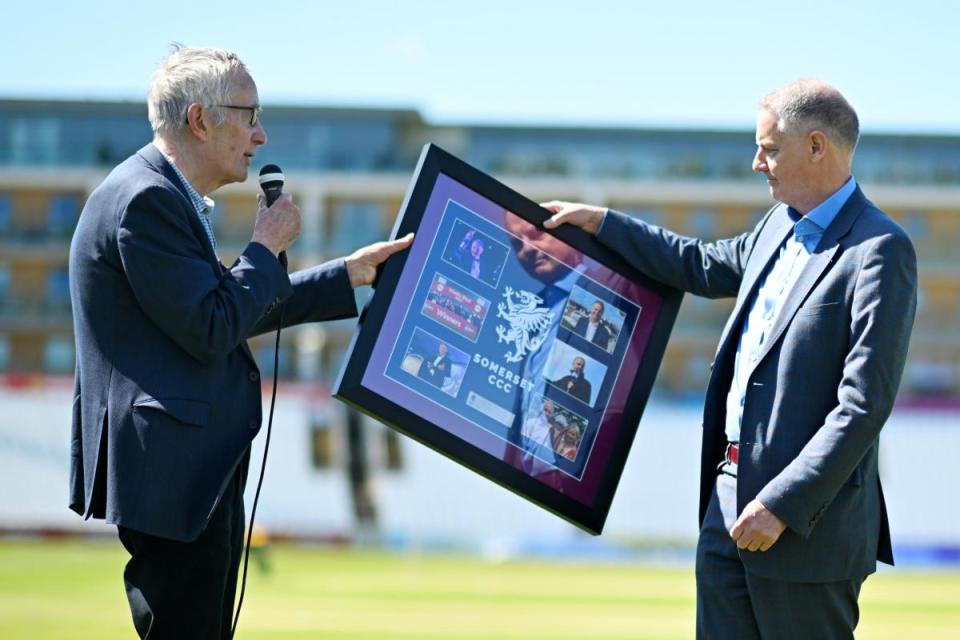 Gordon Hollins being presented a gift by Sir Michael Barber <i>(Image: Somerset CCC/Harry Trump)</i>