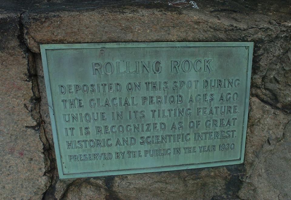 A bronze plaque fixed to the granite pedestal of the Rolling Rock gives a few details about its history.