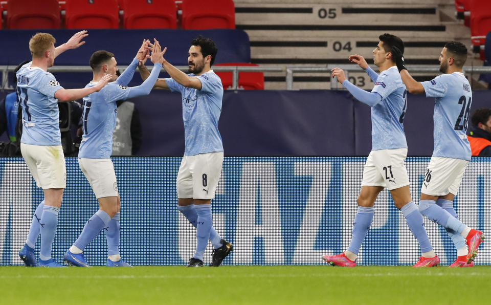 Ilkay Gundogan (centro) del Manchester City es felicitado por sus compañeros tras marcar el segundo gol en el partido contra Borussia Moenchengladbach por los octavos de final de la Liga de Campeones, el martes 16 de marzo de 2021, en Budapest. (AP Foto/Laszlo Balogh)