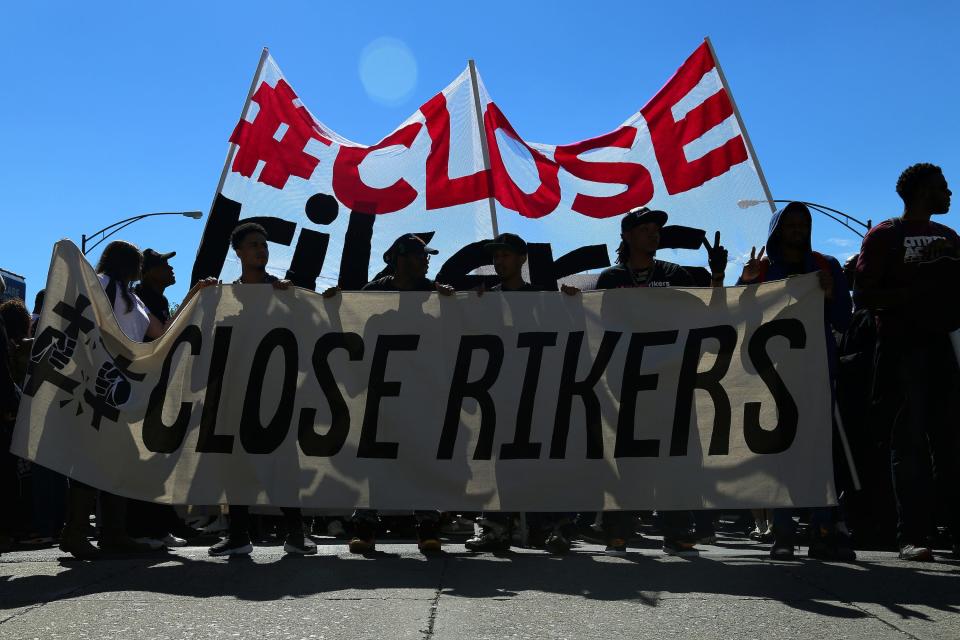 People attend a protest march to shut down Rikers Island prison in the Queens borough of New York