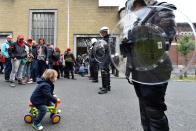 <p>A child rides his toy bike as Belgian prison officers demonstrate on May 17, 2016, behind the Saint-Gilles prison in Brussels, where guards have been on strike for three weeks, protesting pay cuts and working conditions. (Eric Vidal/Reuters)</p>