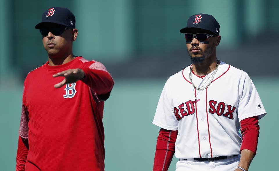 FILE - In this Sept. 16, 2018, file photo, Boston Red Sox manager Alex Cora, left, escorts Mookie Betts off the field during the sixth inning of the team's baseball game against the New York Mets in Boston. Betts drove in just 80 runs last year while spending almost all of his time as the Red Sox leadoff hitter. That seemed like a missed opportunity, so Cora is planning to bat Betts second this season and move Andrew Benintendi to leadoff. (AP Photo/Michael Dwyer, File)