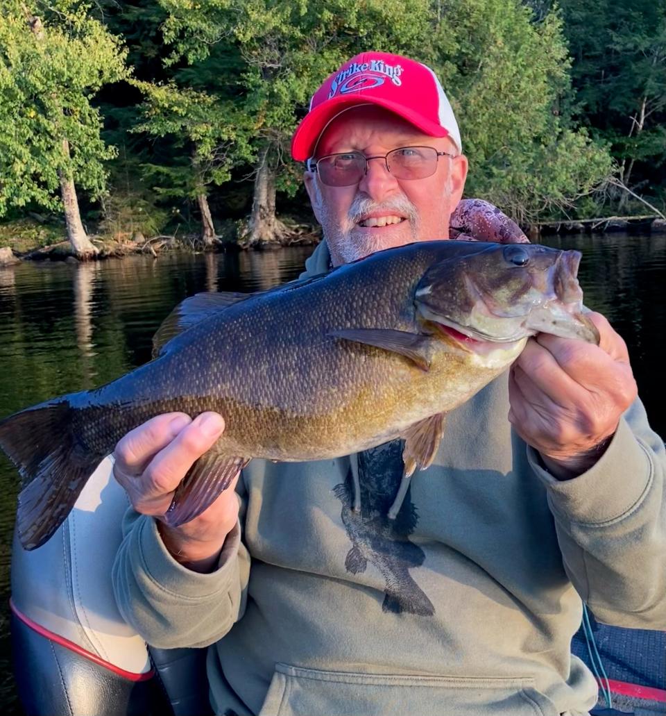 Outdoor correspondent Art Holden shows off the 18-inch smallmouth bass that hit a popper during the evening hours on Cranberry Lake in upstate New York.