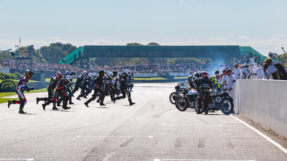 Racers run to their motorcycles during the 2022 Goodwood revival.