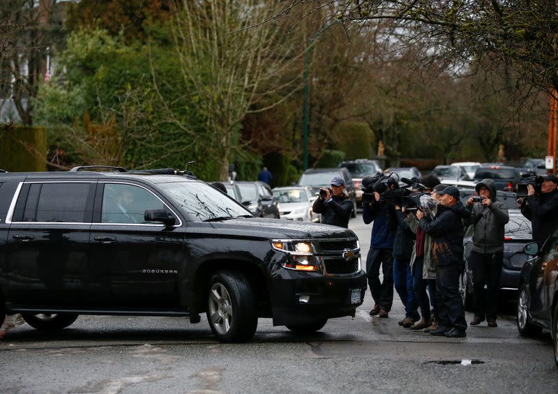 Media photograph a vehicle driving Huawei Chief Financial Officer Meng Wanzhou from her home to attend her extradition hearing in Vancouver