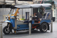 A tuk tuk driver wearing a face mask to help curb the spread of the coronavirus waits for customers in Khao San road, a popular hangout for Thais and tourists in Bangkok, Thailand, Monday, April 26, 2021. Cinemas, parks and gyms were among venues closed in Bangkok as Thailand sees its worst surge of the pandemic. A shortage of hospital beds, along with a failure to secure adequate coronavirus vaccine supplies, have pushed the government into imposing the new restrictions. (AP Photo/Anuthep Cheysakron)