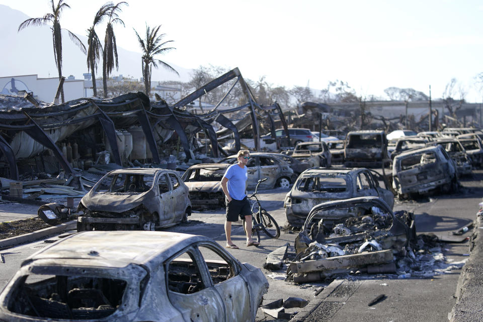 FILE - A man walks through wildfire wreckage Aug. 11, 2023, in Lahaina, Hawaii. Maui authorities said Thursday, Sept. 14, that they are planning to start letting residents and business owners make escorted visits to their properties in the restricted Lahaina Wildfire Disaster area later this month. (AP Photo/Rick Bowmer, File)
